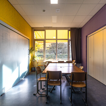 ruimte met vergadertafel en stoelen