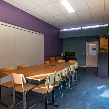 ruimte met vergadertafel en stoelen