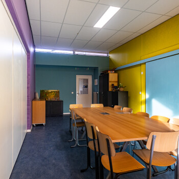 ruimte met vergadertafel en stoelen