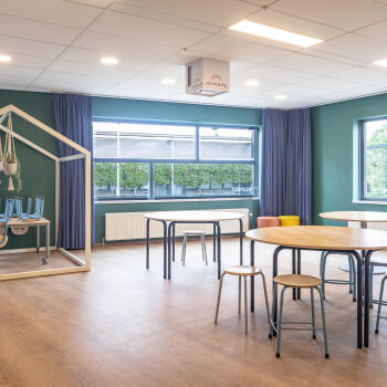 ruimte met ronde tafels met krukken een open huisje met tafel en krukken