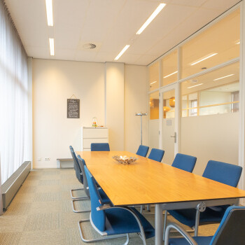 vergaderruimte met tafel en blauwe stoelen
