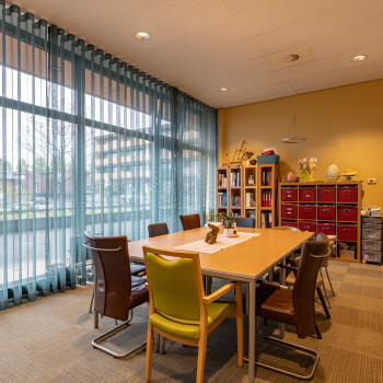 tafel met stoelen, kast, raampartij met vitrage