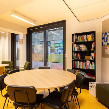 ronde tafel met 4 stoelen, zitbank, gele vloer