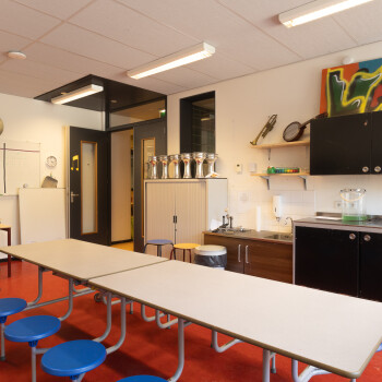 opklaptafels met vaste krukken, spoelbak, rode vloer