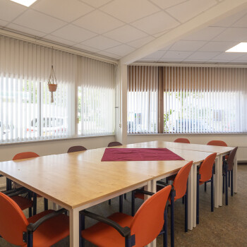 tafels met rode stoelen, raampartij