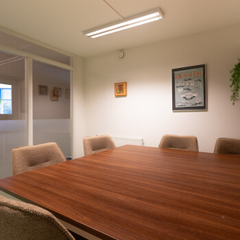 kleur achterwand is wirt. vierkante tafel met stoelen,  schilderij