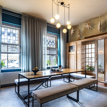 lange tafel met lage zitbanken en en-suite-deuren en ramen