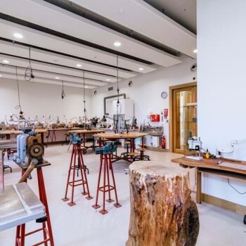 hoge werktafels met zitkrukken, hanglampen, divers gereedschap