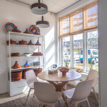 ronde tafel met stoelen en open wandmeubel