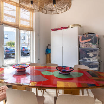 ovale tafel met stoelen, hanglampen en kast