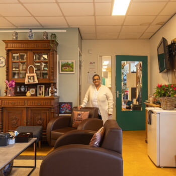 huiskamer met buffetkast, salfontafel, 2 fauteuils en beheerder van De Laarhof