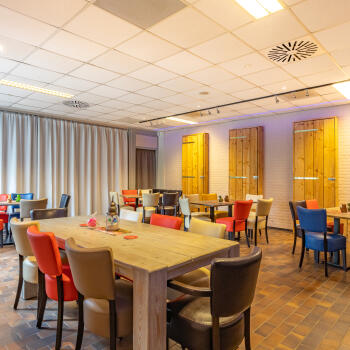 diverse tafels met stoelen met gordijn als scheidingswand