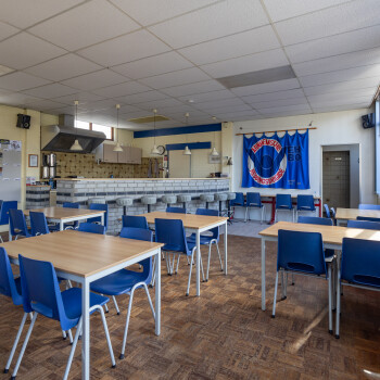 clubhuis met diverse tafels met stoelen en bar