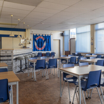 clubhuis met diverse tafels met stoelen 