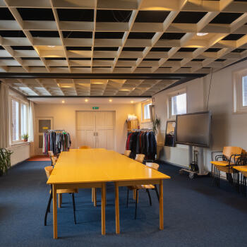 zaal met tafels en stoelen, verrijdbaar groot scherm