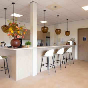 bar met barkrukken, vaas met bloemen