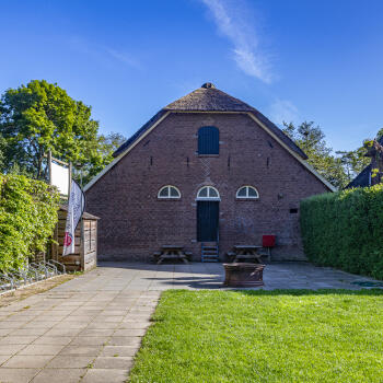 tuin met grasveld en achterzijde van de boerderij/blokhut