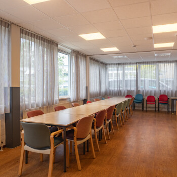 lange tafel met stoelen, houtkleurige vloer