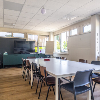 witte tafels met stoelen en houtkleurige vloer