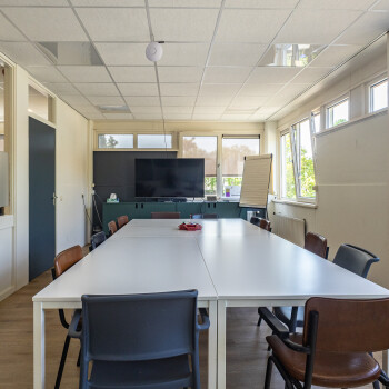 witte tafels met stoelen en TV-scherm