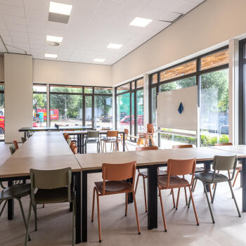 tafels, stoelen, whiteboard, raampartij