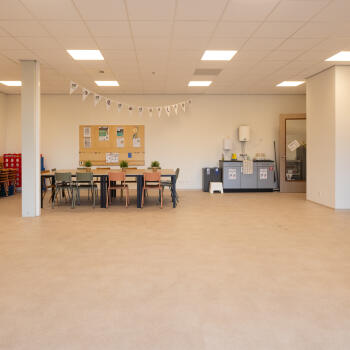 zaal met tafels met stoelen, kasten, pantry